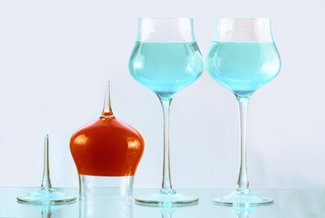 Three wineglasses with blue and orange water