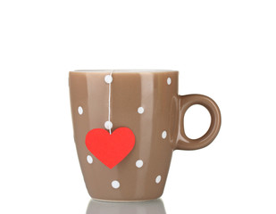 Brown cup and tea bag with red heart-shaped label isolated