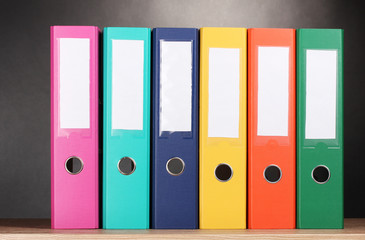 bright office folders on wooden table on grey background