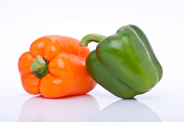 orange und grüne Paprika freigestellt vor weissem Hintergrund
