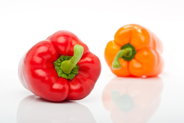 rote und orange Paprika freigestellt vor weissem Hintergrund