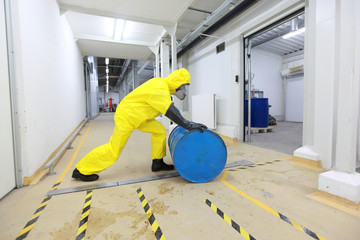 Worker rolling the barrel with toxic substance