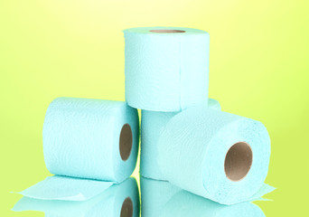 blue rolls of toilet paper on green background