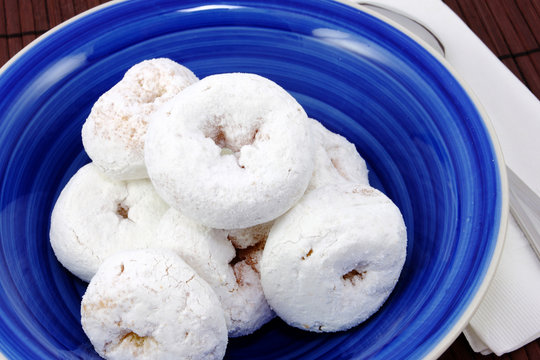 Blue Bowl With White Mini Powdered Sugar Doughnuts