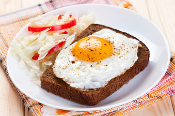 Fried egg on slice bread.