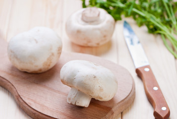 Mushrooms champignons on cutting board.