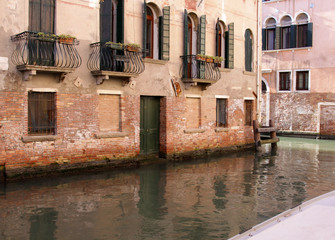 A canal in Venice, Italy, lined with a building with balconies.