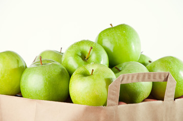 Granny Smith apples in a paper bag, isolated over white