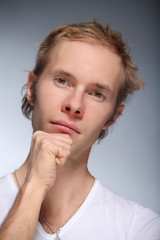 Pretty young man posing on light background