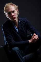 Pretty young man posing on black background