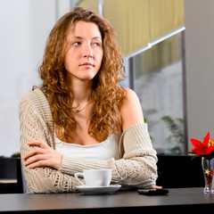 young woman is sitting at cafe