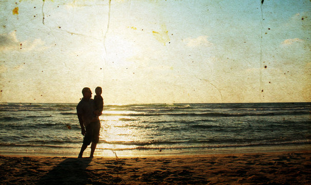 Father and son at sea watching the sunset. Photo in old image st