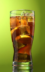 Iced tea with lemon and lime on green background