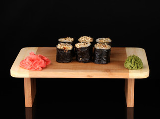 Tasty rolls served on wooden plate isolated on black