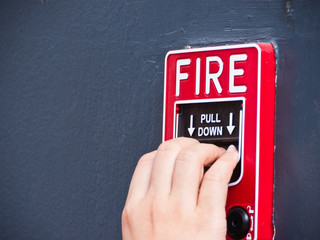 Hand on fire alarm box