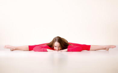 Fototapeta na wymiar Dancer woman sit on floor in dance studio and stretching