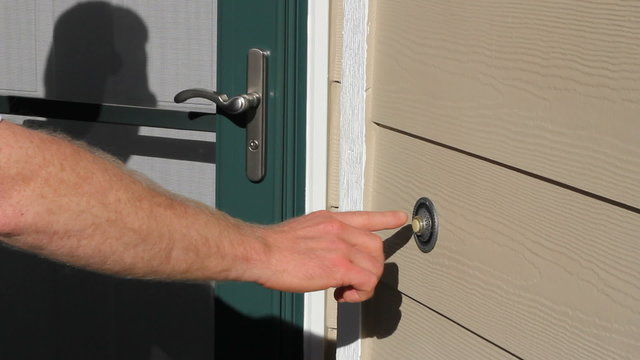 Man Ringing Front Door Bell of a Home on a Sunny Summer Day