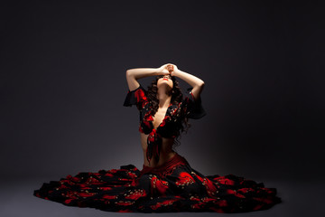 young woman sit in gypsy black and red costume - obrazy, fototapety, plakaty
