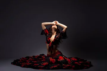 Poster young woman sit in gypsy black and red costume © Wisky