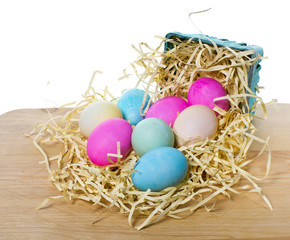 Fototapeta na wymiar Small basket with colorful eggs spilling out
