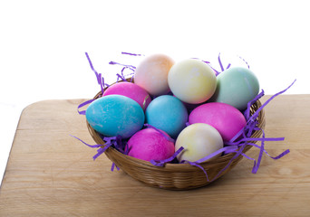 Wicker basket of colored eggs and straw