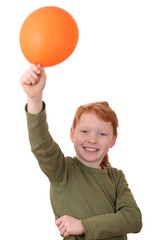 Fototapeta na wymiar Junges rothaariges Mädchen mit einem orangen Ballon