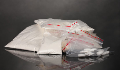 Cocaine and drugs in packages on grey background