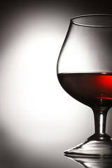 Glass of cognac on grey background