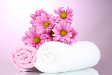 Obraz na płótnie Canvas towels and beautiful flowers on pink background