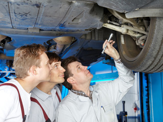 Master mechanic and his employees checking a car