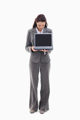 Businesswoman looking and showing a laptop screen