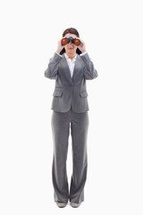 Businesswoman looking through binoculars