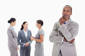 Thoughtful businessman looking up with co-workers