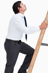 Side view of tradesman climbing a ladder