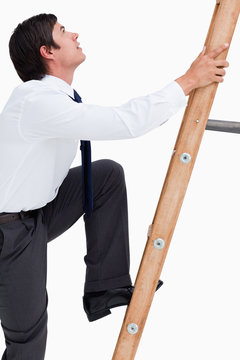 Side View Of Young Tradesman Climbing A Ladder