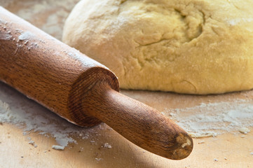 Dough on wooden board.
