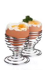 boiled eggs in metal stands and parsley isolated on white