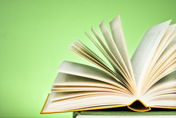 An open book on a pile of  other books books