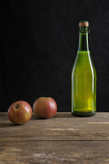 bottle of cider and apples on old table