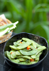 Green beans with red chilli in black bowl