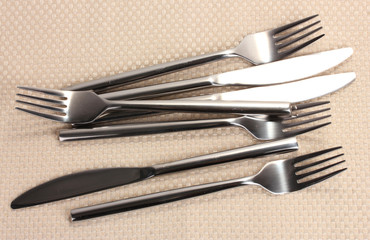 Forks and knives on a beige tablecloth