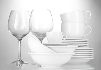 empty bowls, plates, cups and glasses on grey background