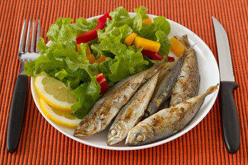 fried fish with lemon and salad