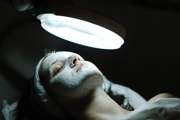 woman with facial mask in cosmetic studio