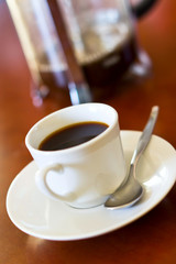 black coffee prepared in a glass jug in background