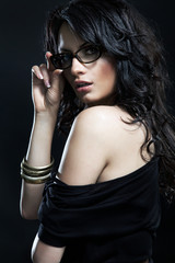 Naklejka premium Portrait of a woman in modern glasses over black isolated backgr