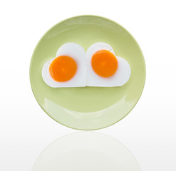 Fried egg  heart on green dish