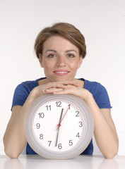 Joven mujer sosteniendo un reloj.