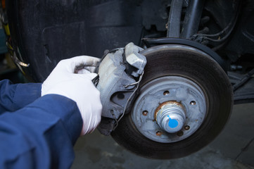 mechanic repairs a car in a garage