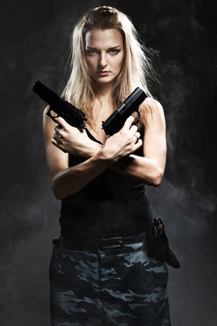 Sexy woman holding gun with smoke